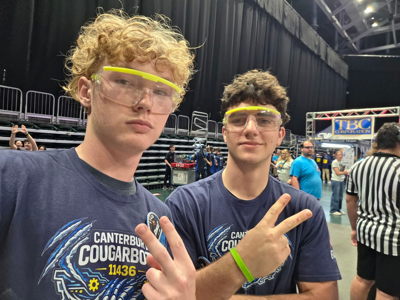 Stephan and a teammate in Canterbury Cougarbots shirts and safety glasses on the FRC competition floor